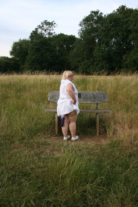 Fat British lady Lexie Cummings exposes herself on a bench in a field