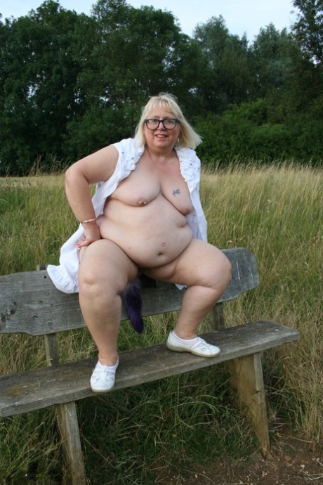 Fat British lady Lexie Cummings exposes herself on a bench in a field