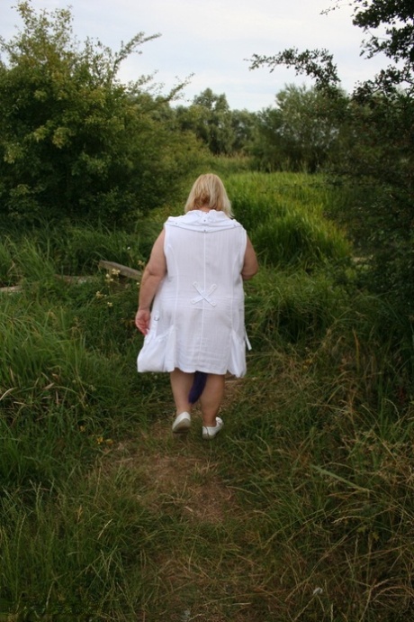 Fat British lady Lexie Cummings exposes herself on a bench in a field