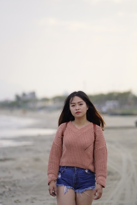 Stunning Asian babe poses in her jean shorts & sweater in public