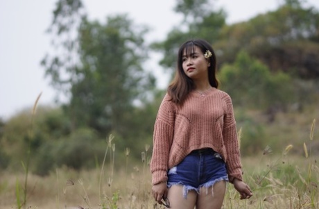 Stunning Asian babe poses in her jean shorts & sweater in public
