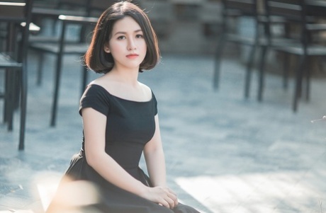 Glamorous Asian babe posing in her elegant black dress in public