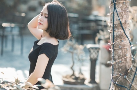 Glamorous Asian babe posing in her elegant black dress in public