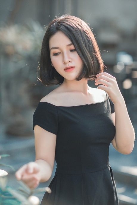Glamorous Asian babe posing in her elegant black dress in public
