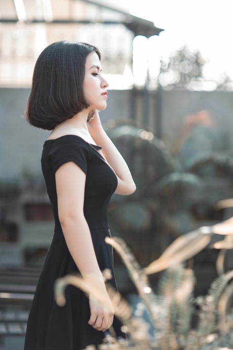 Glamorous Asian babe posing in her elegant black dress in public