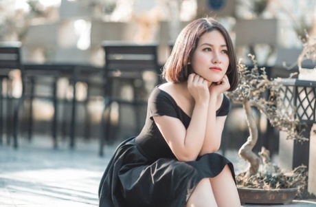 Glamorous Asian babe posing in her elegant black dress in public