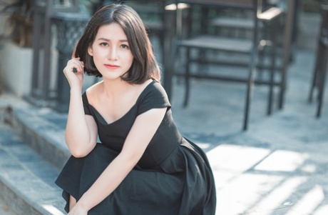 Glamorous Asian babe posing in her elegant black dress in public
