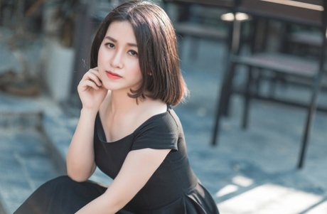 Glamorous Asian babe posing in her elegant black dress in public