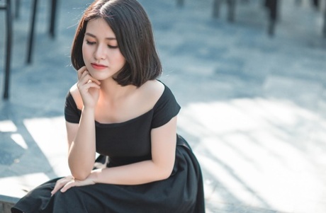 Glamorous Asian babe posing in her elegant black dress in public