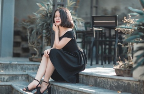 Glamorous Asian babe posing in her elegant black dress in public
