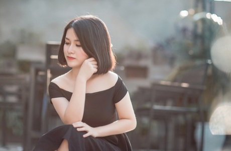 Glamorous Asian babe posing in her elegant black dress in public