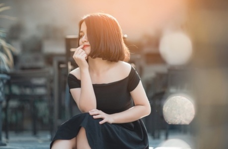 Glamorous Asian babe posing in her elegant black dress in public