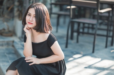 Glamorous Asian babe posing in her elegant black dress in public
